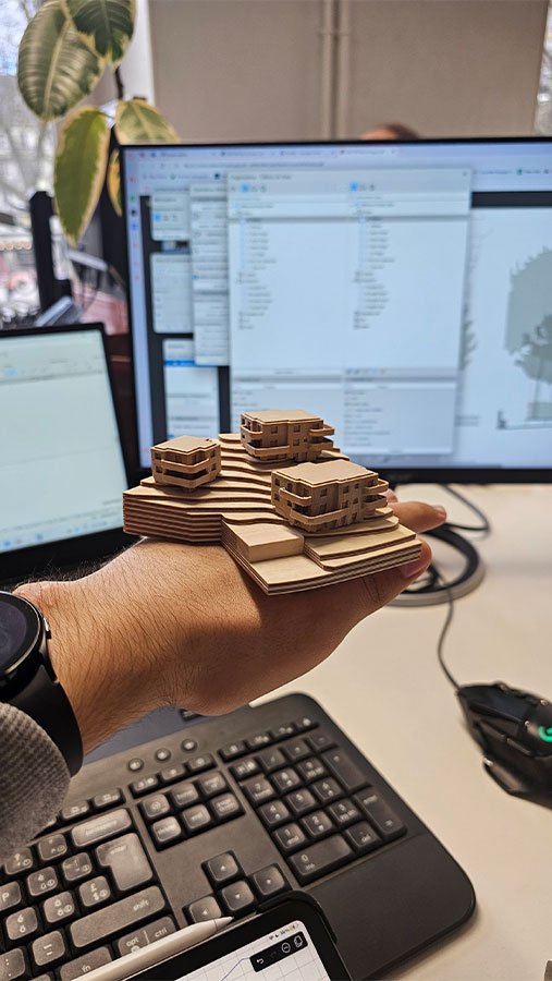 Maquette topographique en relief tenue dans la main devant un poste de travail