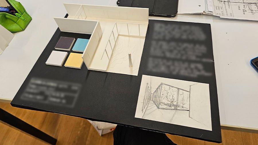 Maquette architecturale et éléments de façade disposés sur une table noire